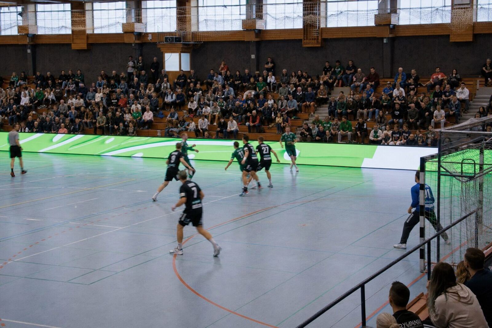 Sporthalle mit LED-Bande während eines Handballspiels